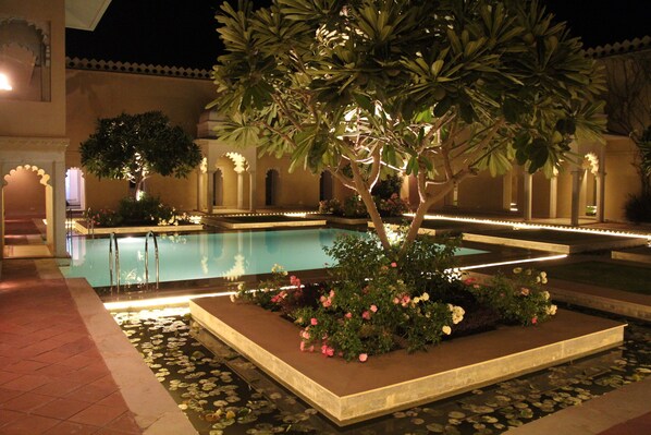Una piscina al aire libre, tumbonas