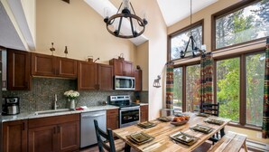 Una cucina moderna con mobili in legno, un'isola grande e un'area pranzo con una panca.