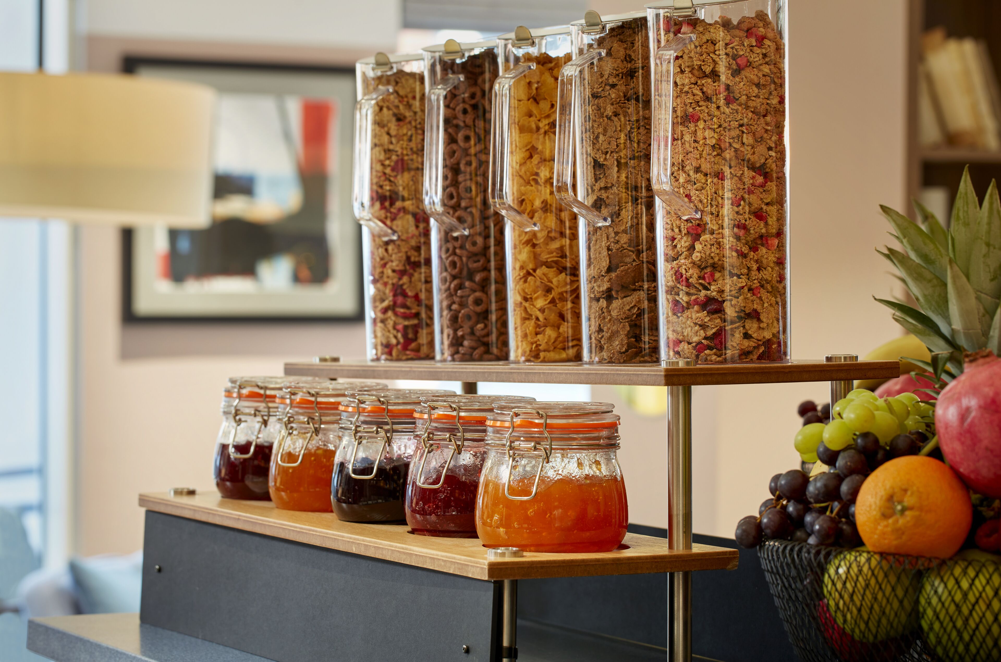 Een presentatie van eten met potten jam en een fruitmand.