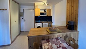 A compact kitchen with wooden cabinets, a microwave, a sink, and a coffee machine. - Apartment in Lanslebourg Village, Val Cenis - 300m from Ski Slopes (Lanslebourg-Mont-Cenis)