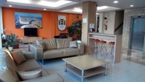 Un vestíbulo moderno con un sofá, una mesa de centro y una zona de bar con taburetes.