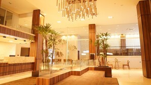 A spacious lobby with a reception desk, seating area, and a modern chandelier. - Forte Express (Macapa)