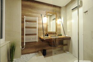 A bathroom with a wooden vanity, a white towel rack, a mirror, and a glass shower enclosure.