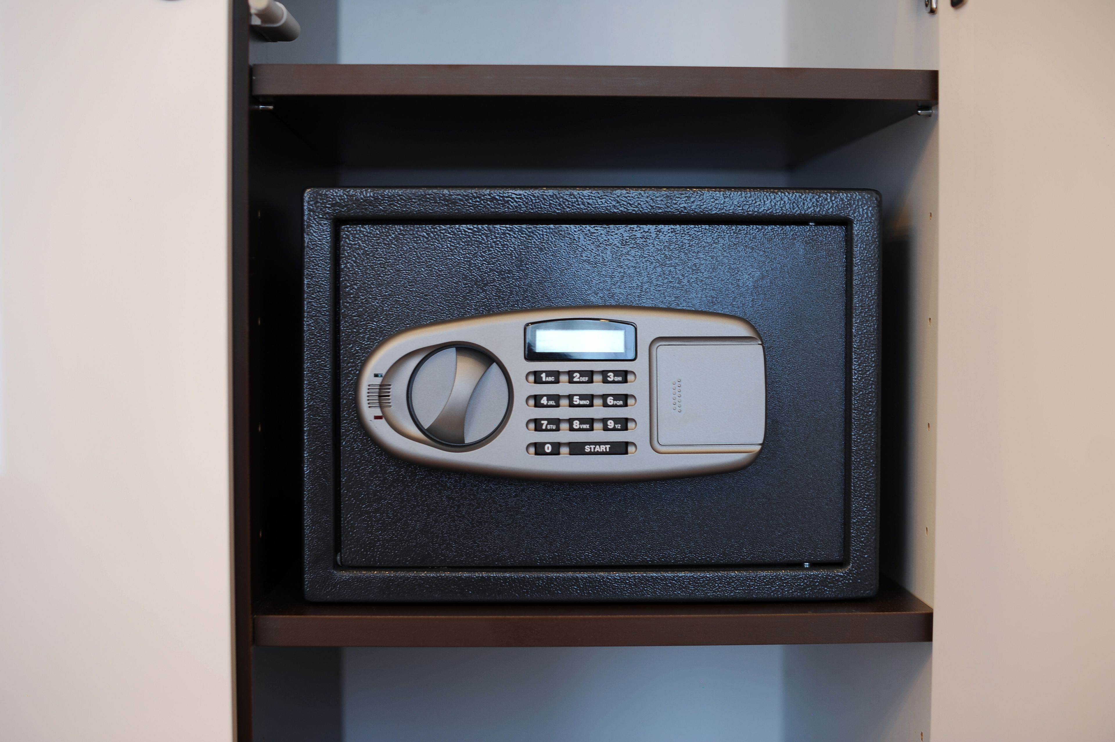 A device with a keypad and a dial, likely a security system, in a drawer.