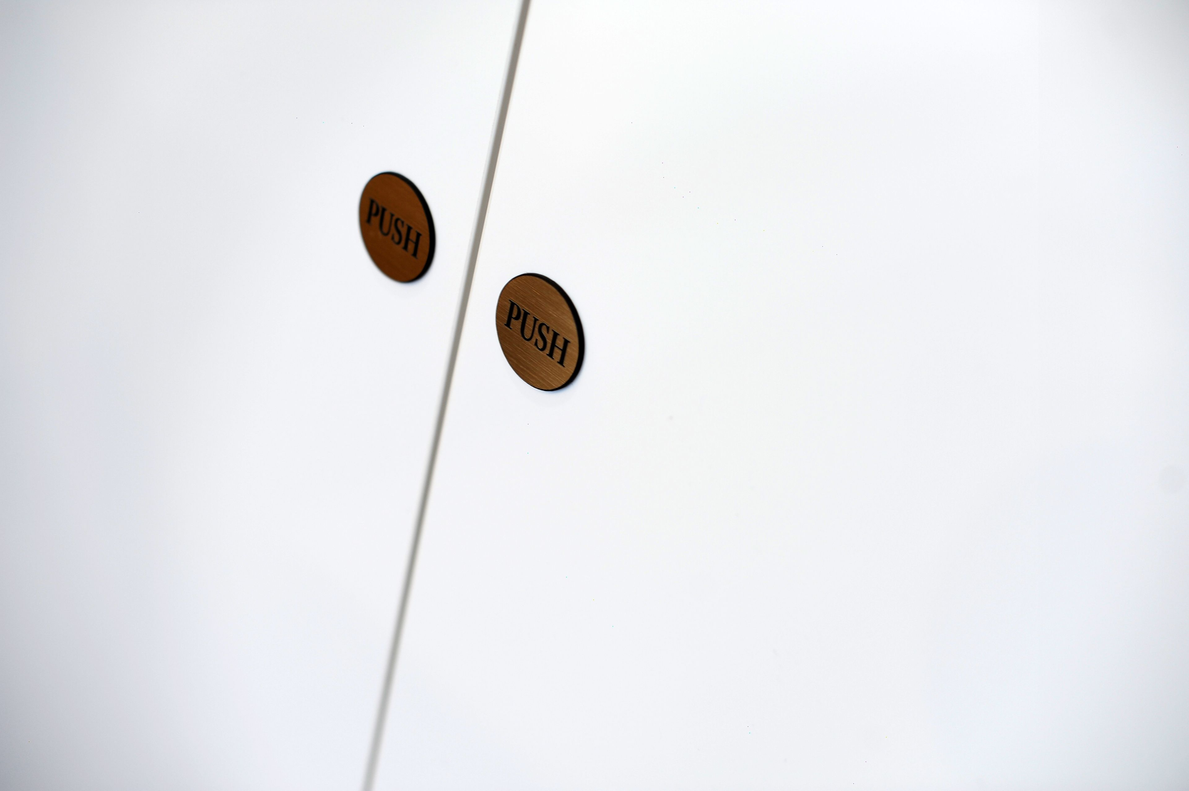 Two wooden push buttons on a white surface.