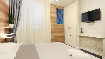 A modern hotel room with a large bed, a TV mounted on the wall, a wooden accent wall, and a decorative painting.