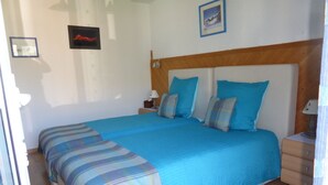A bedroom with a large bed, wooden headboard, and a nightstand with a lamp. - B&B Les Acacias (Bagnes)