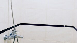 A corner shower with a handheld showerhead and a flexible hose. - Hostel Train Station (Kyiv)
