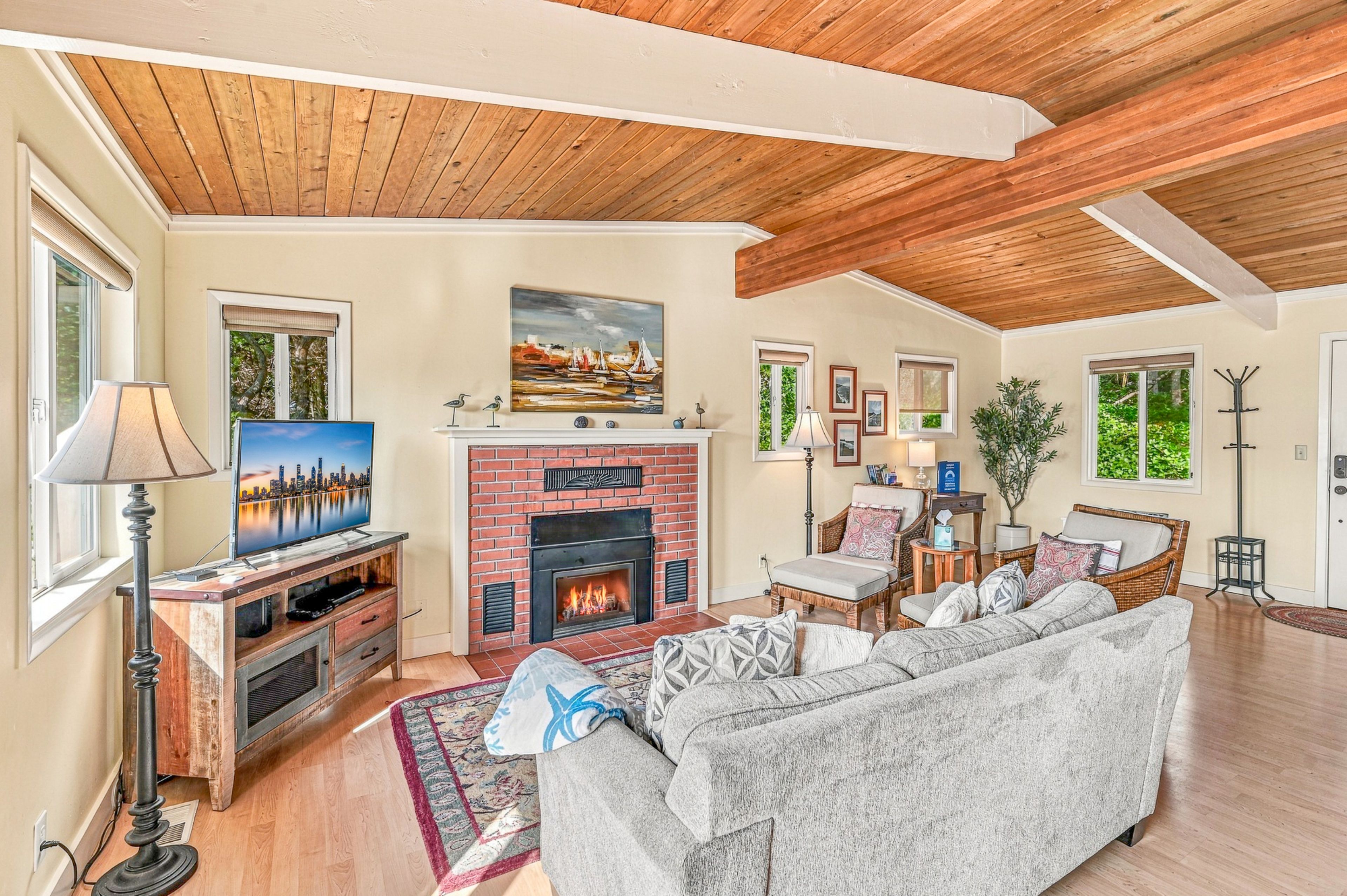 Una sala de estar con chimenea, televisor y sofá.