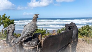 A sculpture of a bird overlooking the ocean.
