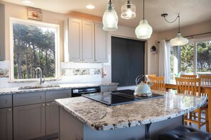 Enjoy cooking in this well-equipped kitchen with a large island, stovetop, and dining area.