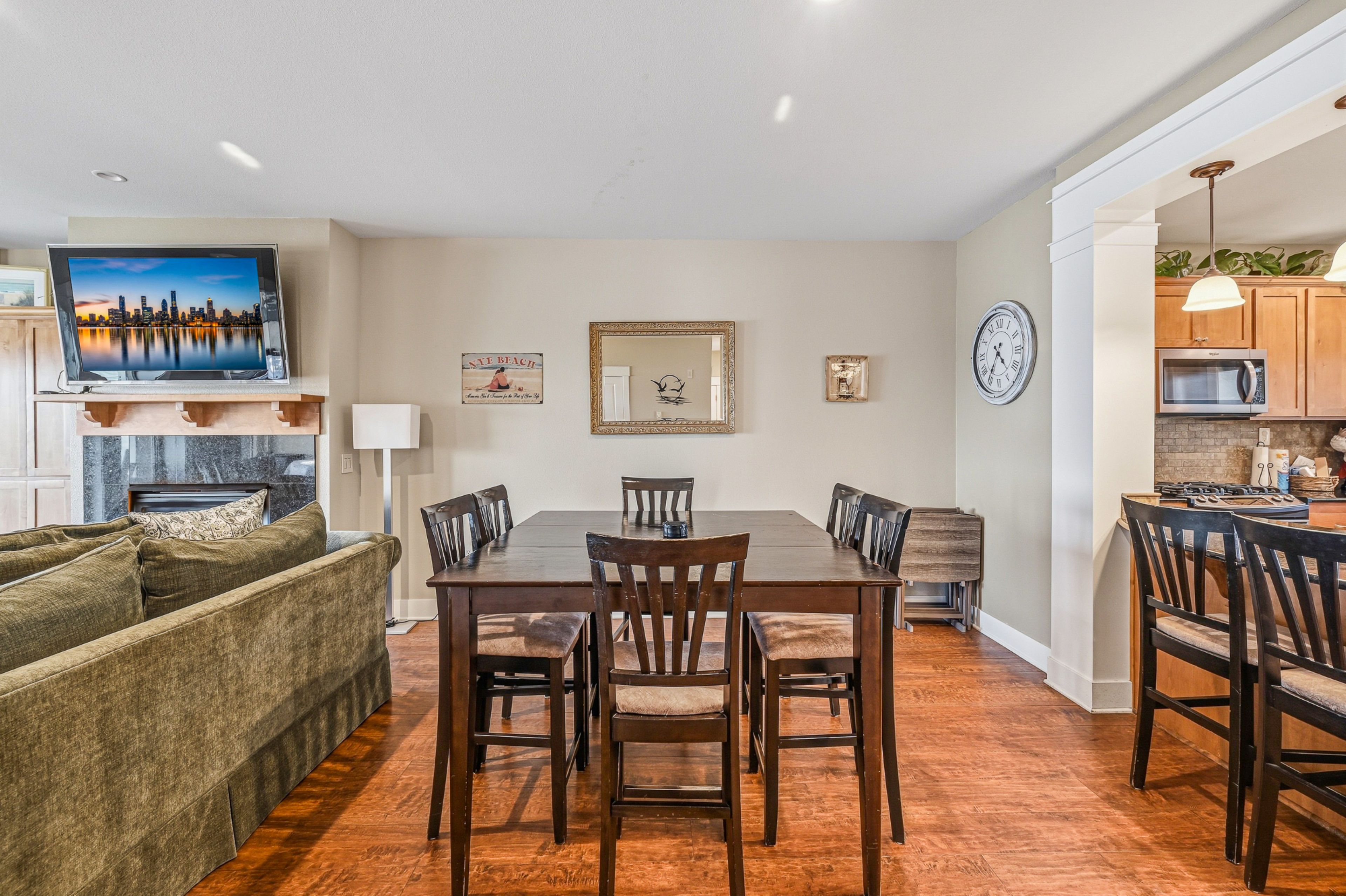 A modern living space with a dining area, kitchen, and seating area.