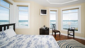 Une chambre à coucher avec un lit, une chaise, un bureau et un téléviseur.