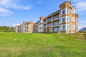 Een rij moderne woongebouwen met balkons, voor een heldere lucht.