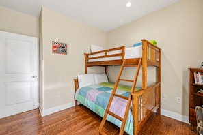 A bunk bed with a ladder, a door, a wall with a poster, and a small bookshelf. - Panoramic Pacific Views at this 2nd floor luxury oceanfront condo, beach access (Newport)