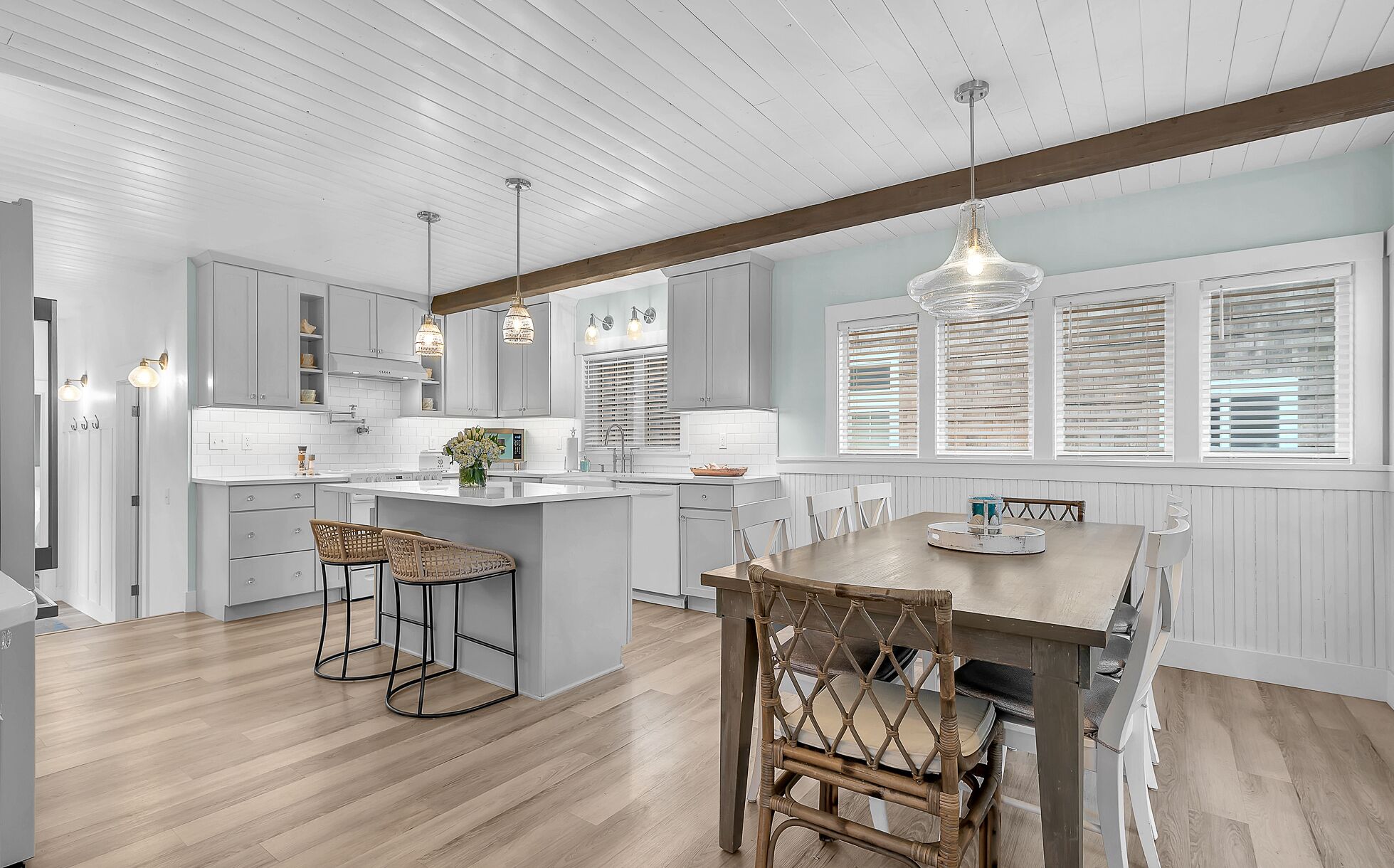 Una cocina moderna con armarios blancos, una isla central e iluminación colgante.