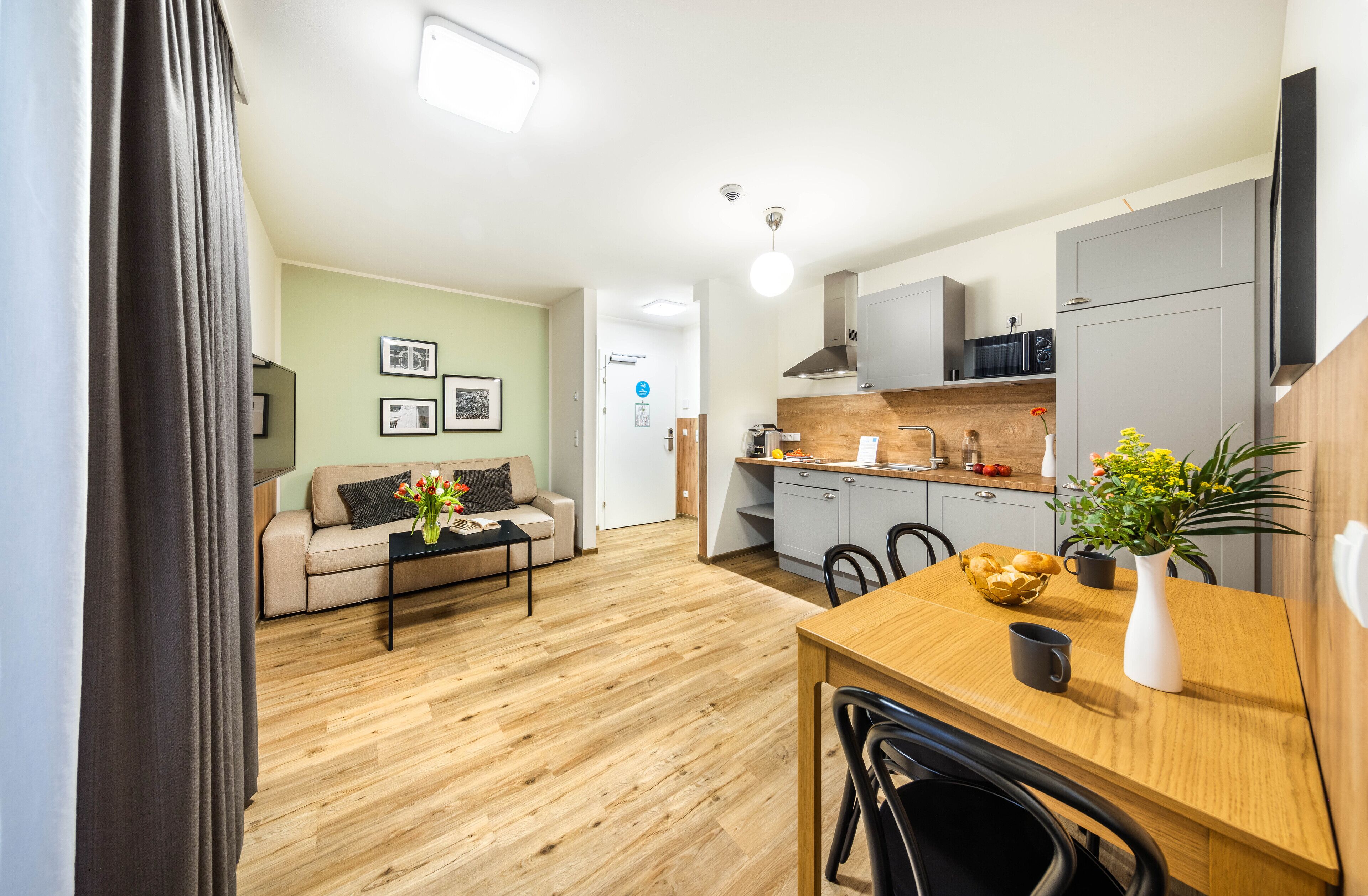 A modern apartment with a living room, kitchen, and dining area.