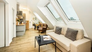 A modern apartment with a loft bedroom, a dining area, and a living room with a sofa and a coffee table. - Jimmy's Apartments Lory (Vienna)