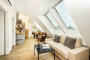 Suite, 2 habitaciones, balcón | Área de sala de estar | Televisión de pantalla plana y piso con calefacción