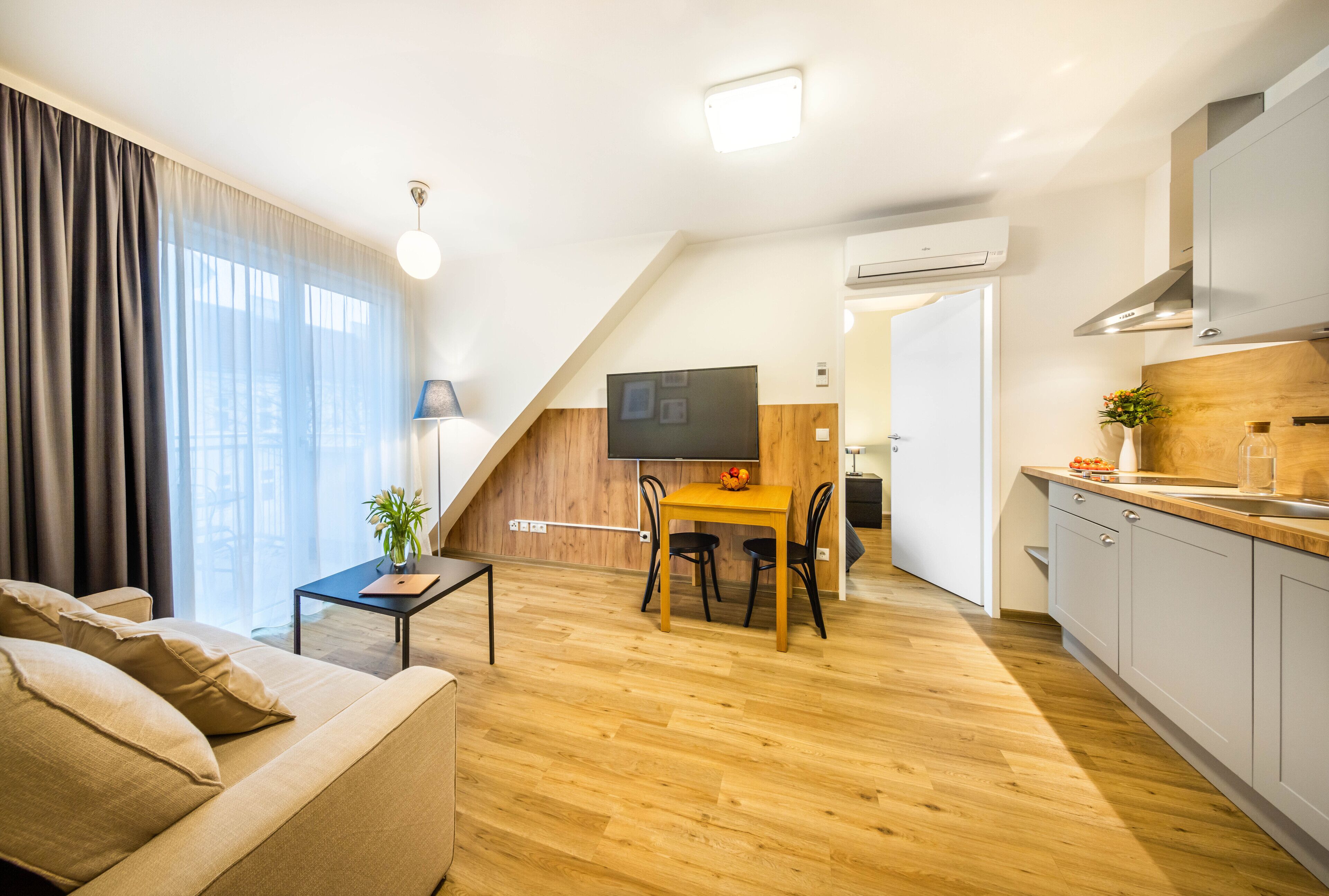 A modern apartment with a living room, dining area, and kitchen.