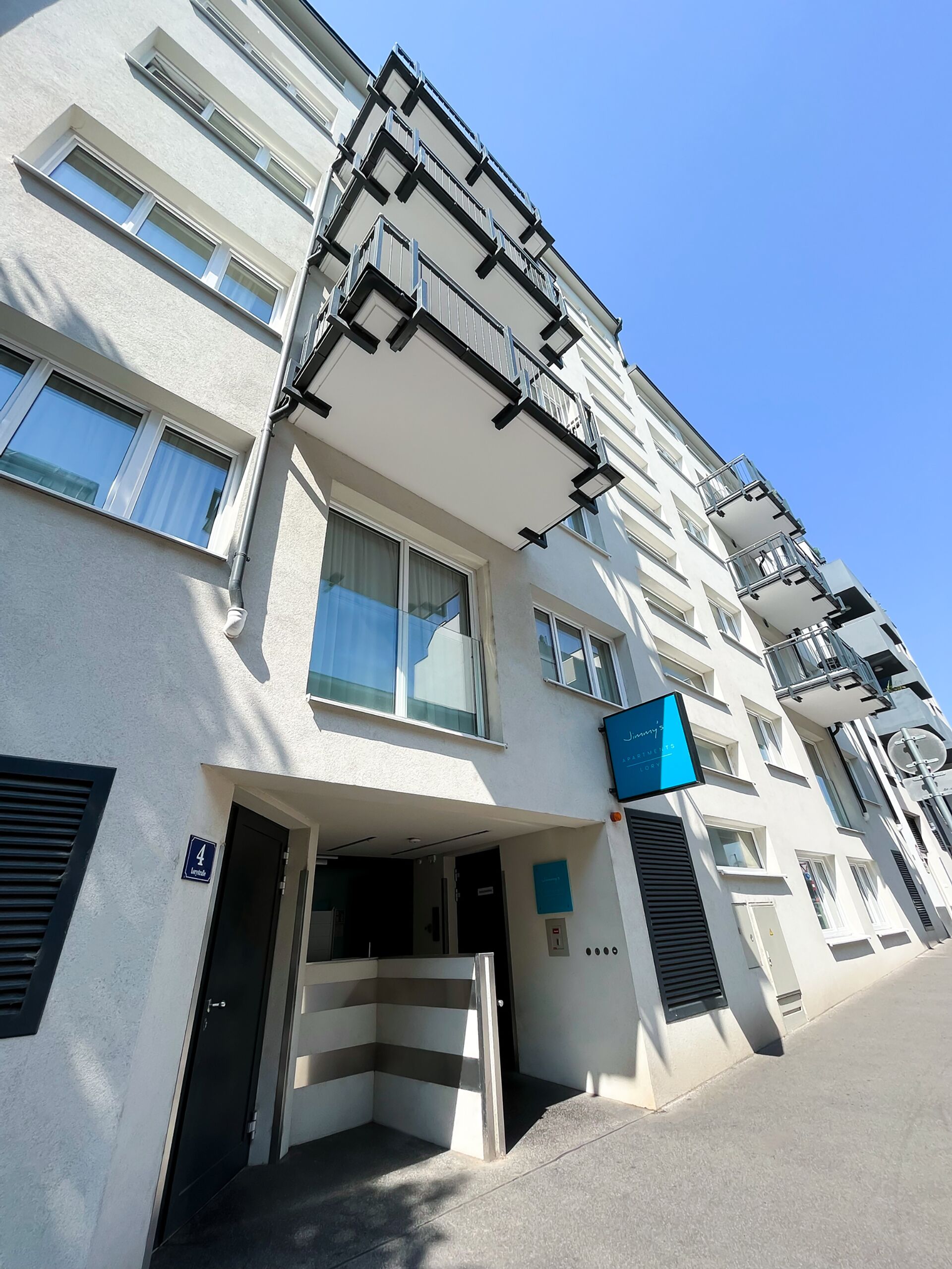 Un edificio moderno a più piani con facciata lineare, ampie finestre e insegna blu che indica un hotel.