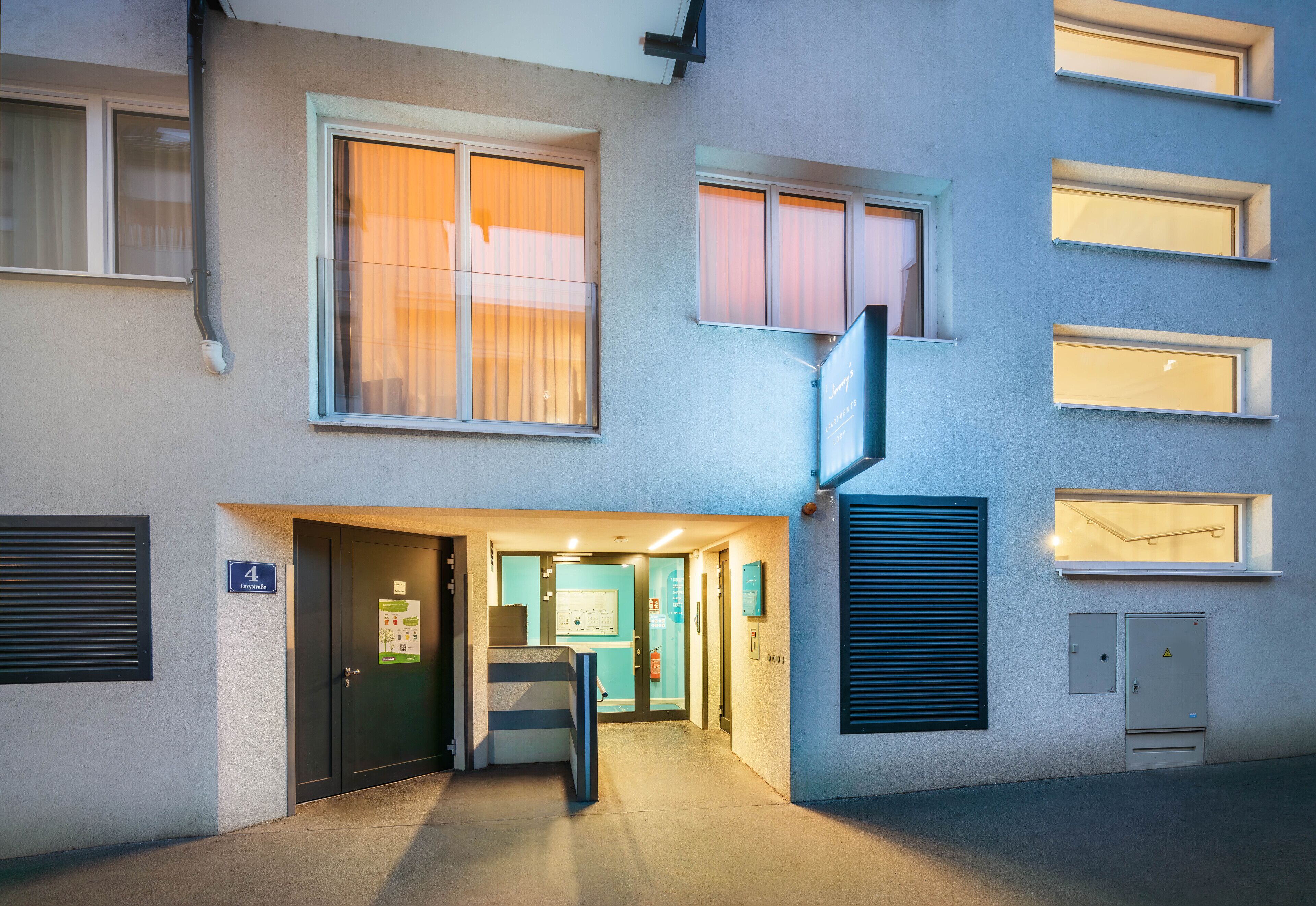Entrada de un edificio con una puerta marcada con el número 4 y una escalera que sube a un piso superior.