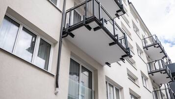 Un edificio de varios pisos con balcones exteriores, un letrero que dice "Jimmy's" y una puerta que da a la entrada.