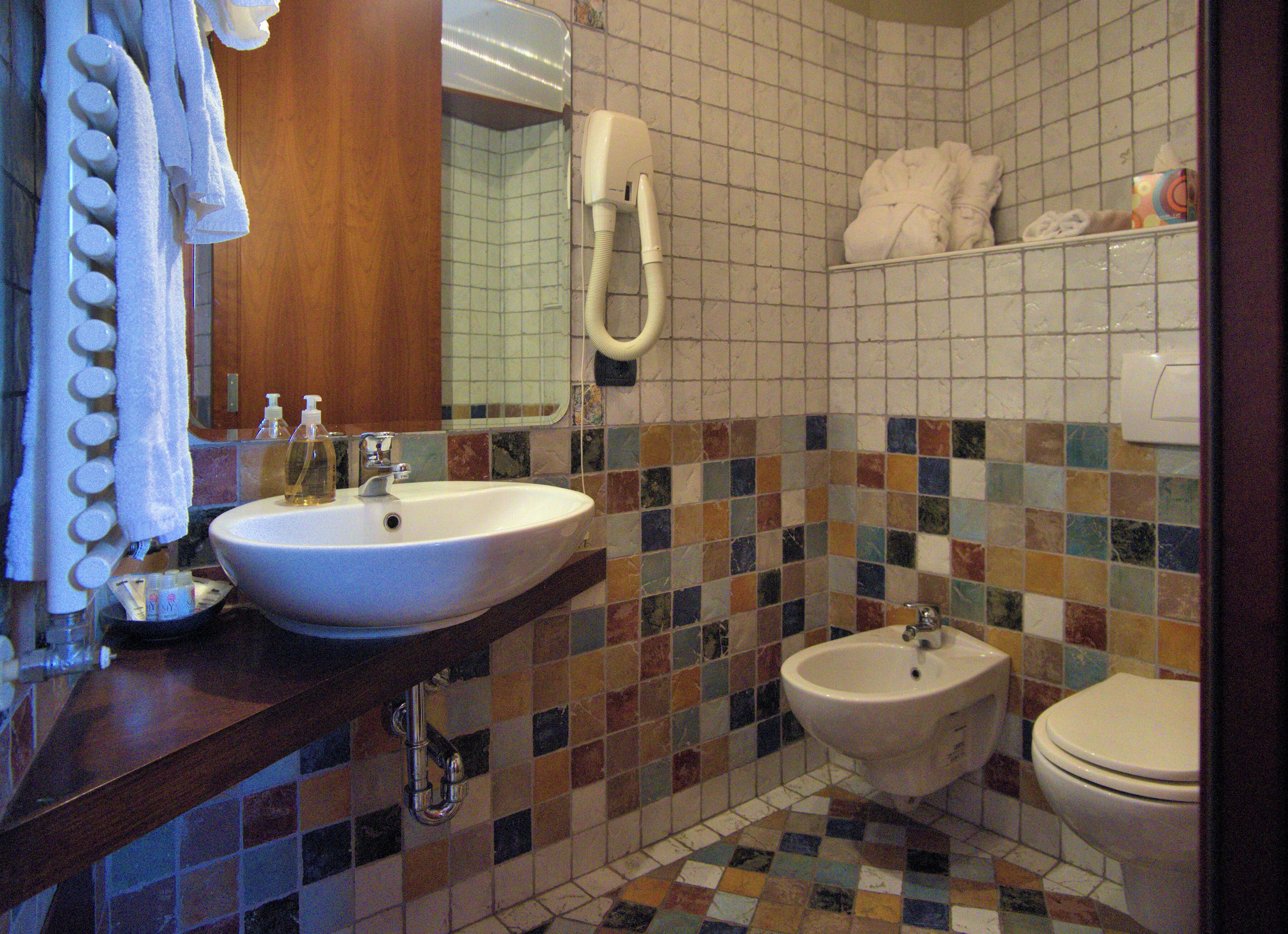 A bathroom with a sink, bidet, and toilet.