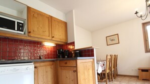A kitchen with wooden cabinets, a microwave, a coffee maker, and a dishwasher.