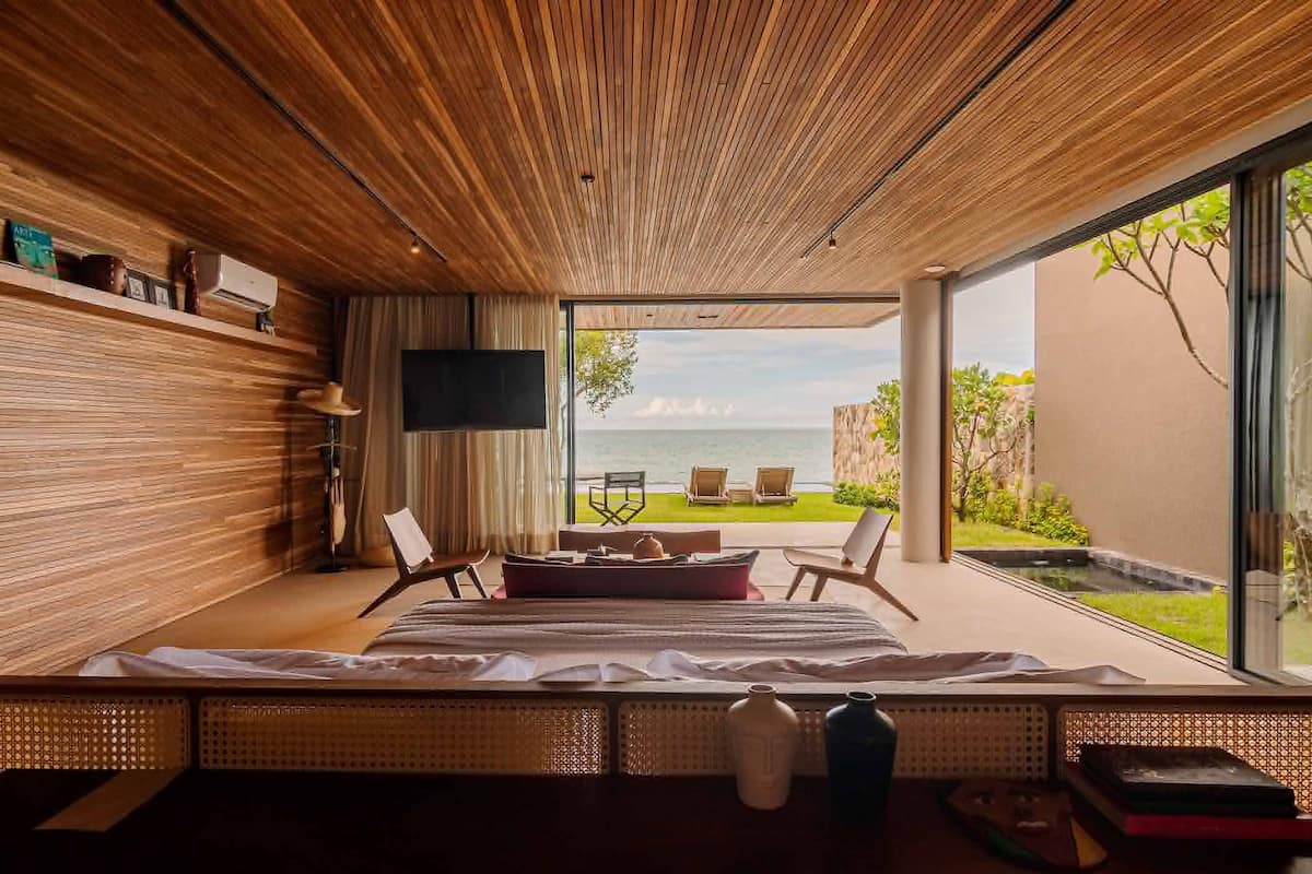 Une chambre moderne avec un grand lit, une télévision et une vue sur la mer.