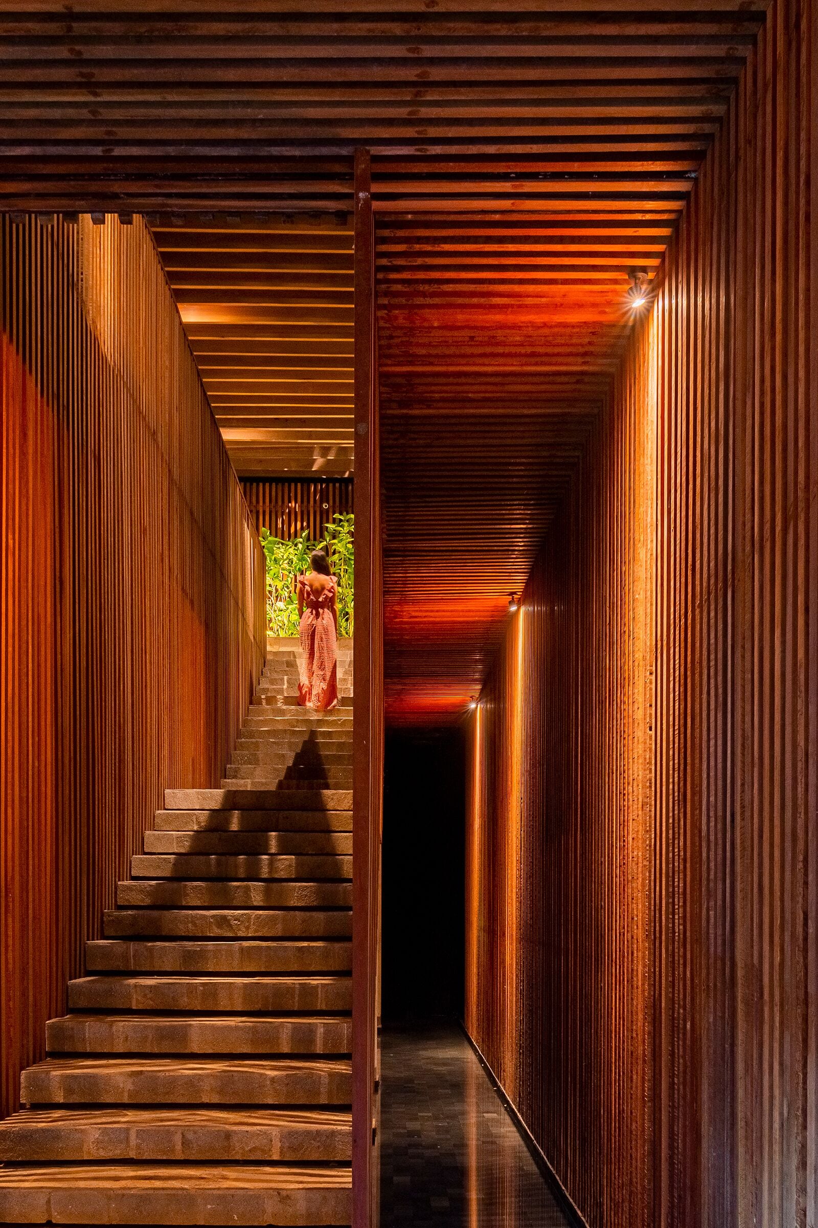 A wooden interior with a staircase leading to a bright area.
