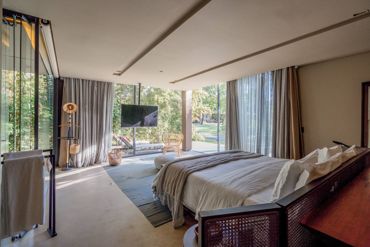 Une chambre d’hôtel moderne dotée d’un grand lit, d’une télévision et offrant une vue sur l’extérieur.
