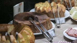 A display of various cakes and pastries, including a bundt cake and a slice of cake on a plate. - Tokyo Hotel (Tres Lagoas)