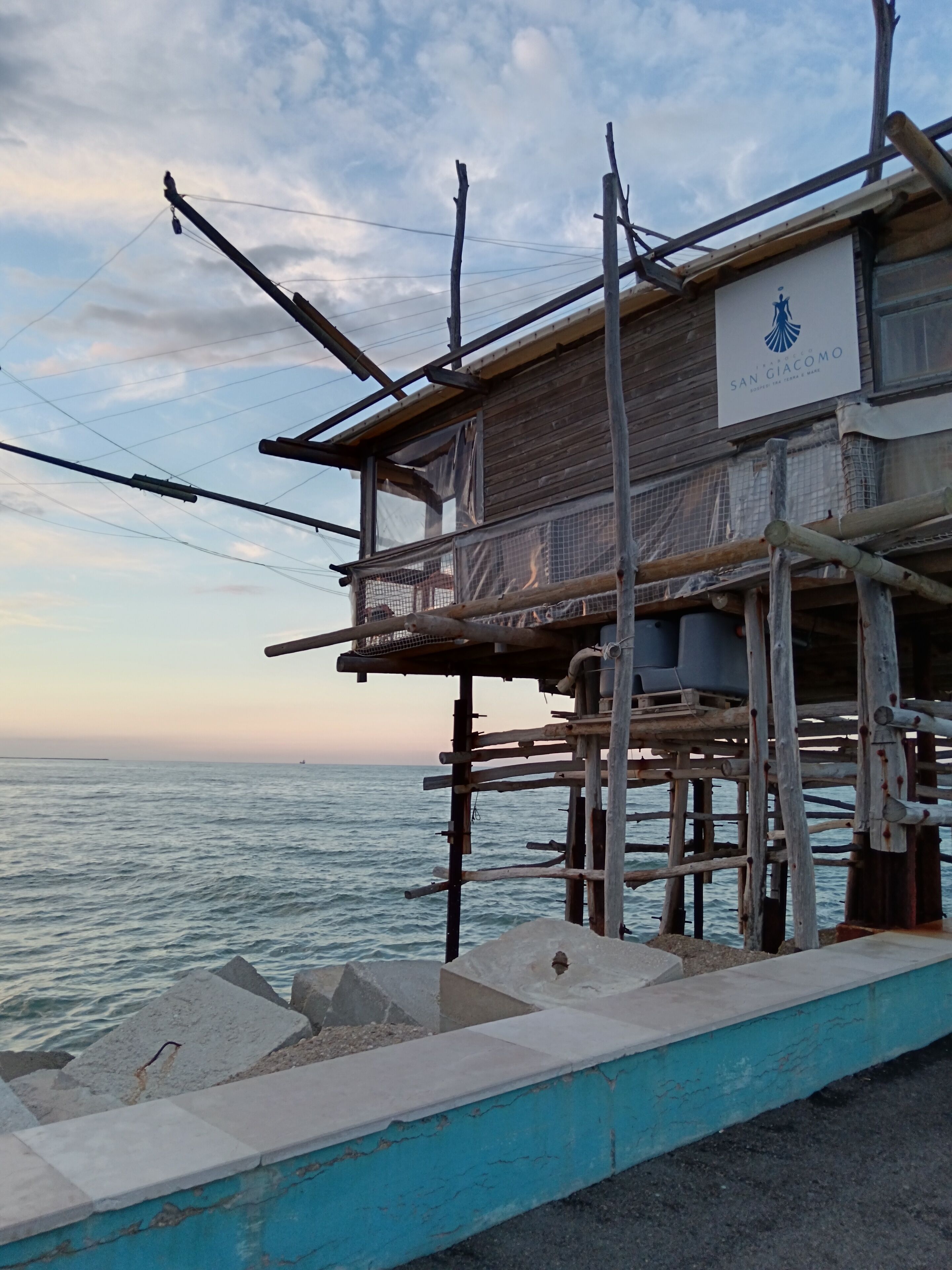A wooden structure with a sign reading "San Giacomo" by the sea.