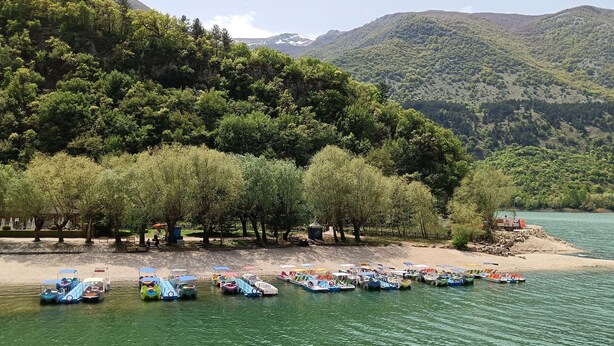 A lakeside area with boats docked along the shore, surrounded by lush greenery and hills. - Prati di Maja B&B (Miglianico)