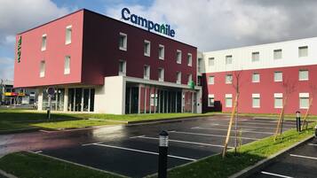 Un hôtel moderne à la façade bordeaux et à l’enseigne verte portant l’inscription « Campanile ».