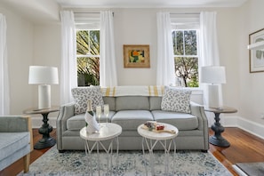 Relax in this stylish living room with a comfortable sofa, side tables, and a round coffee table.