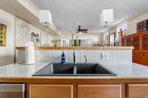 Enjoy cooking in this well-equipped kitchen with a central island, double sink, and stove.