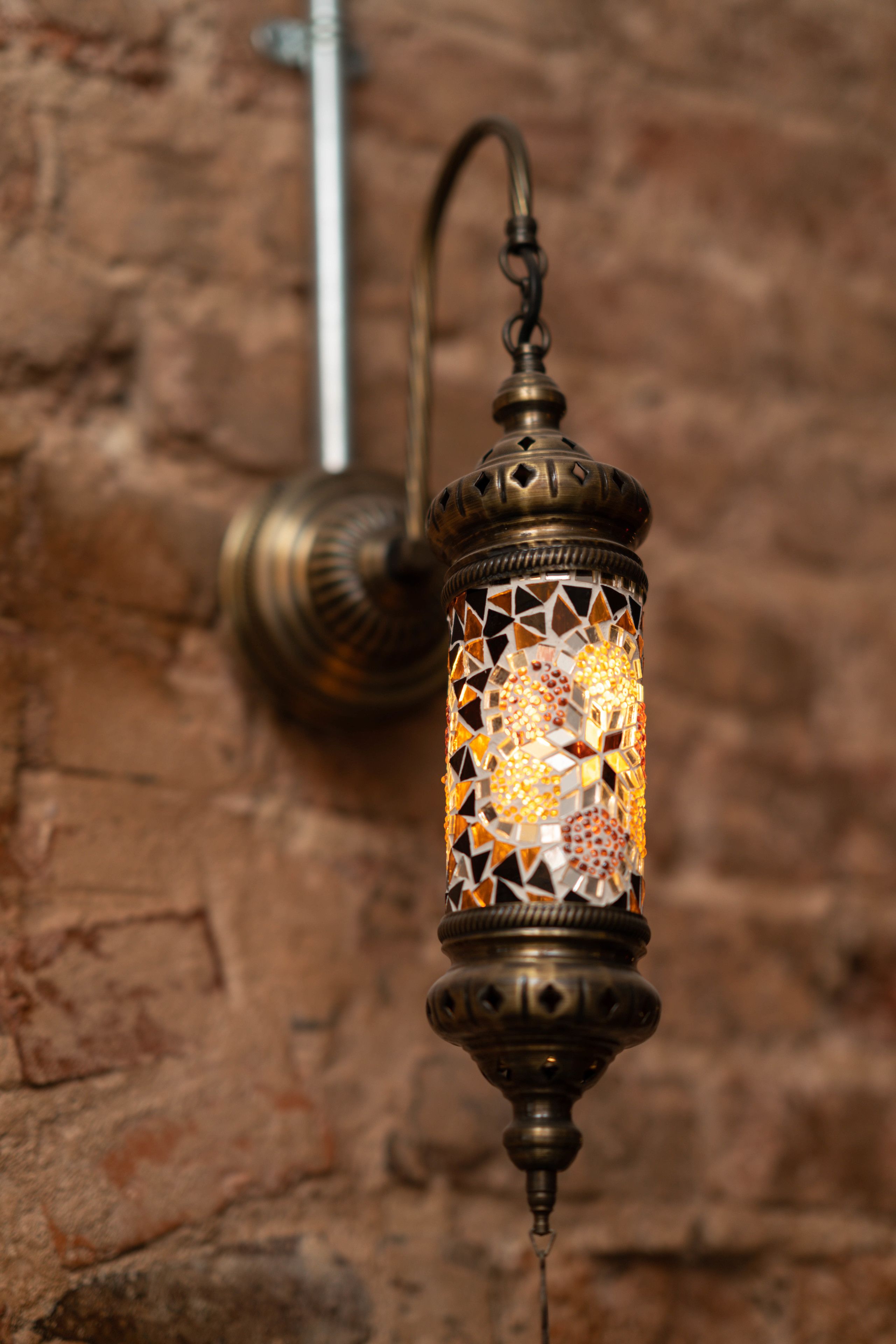A wall-mounted lantern with a geometric pattern and a hook.