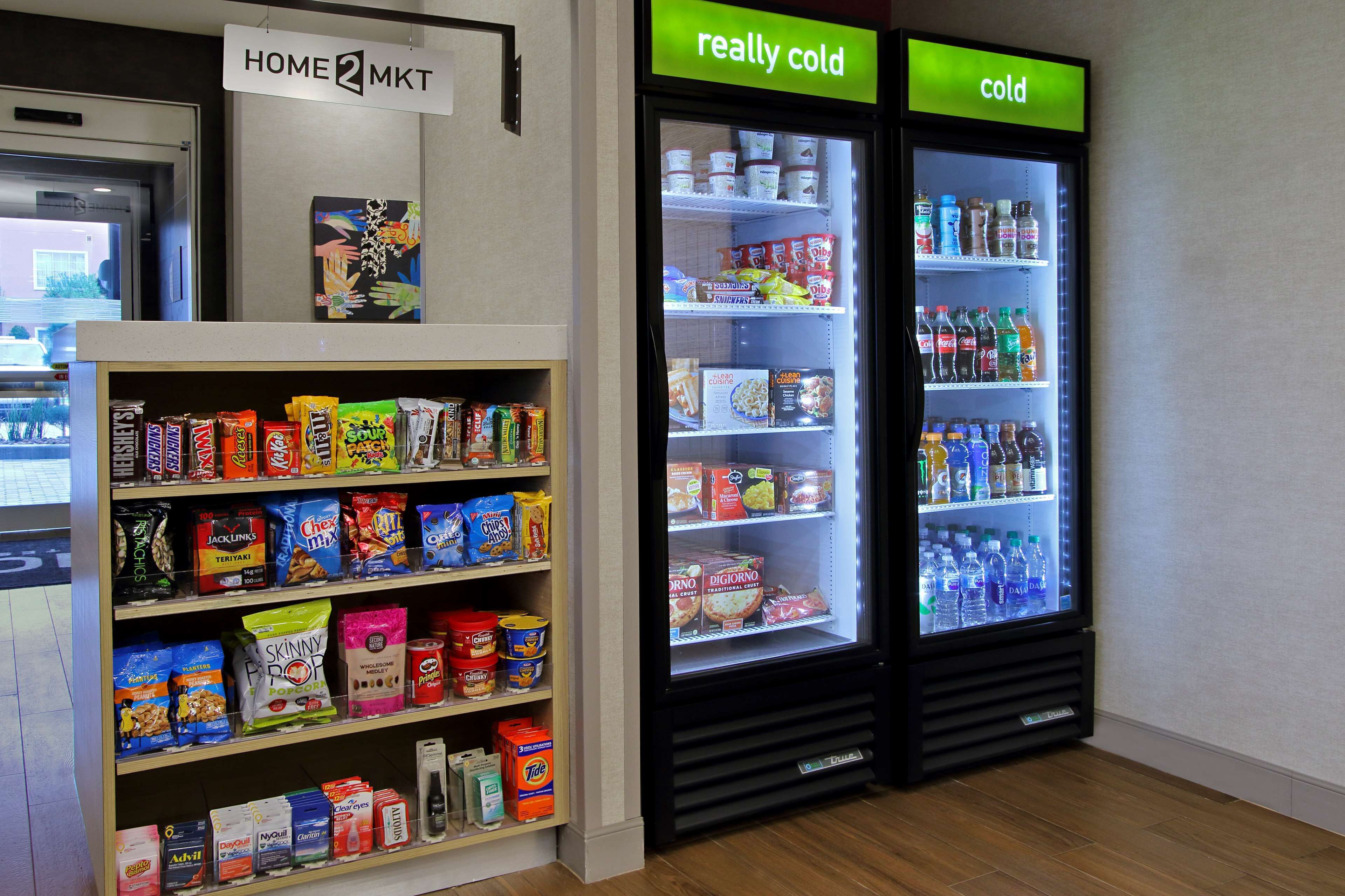 A snack and beverage display area with shelves stocked with various snacks and a refrigerated section with drinks.