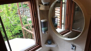 A bathroom with a window, a sink, a mirror, and a soap dispenser. - Apartments Tarcizio (Cres)