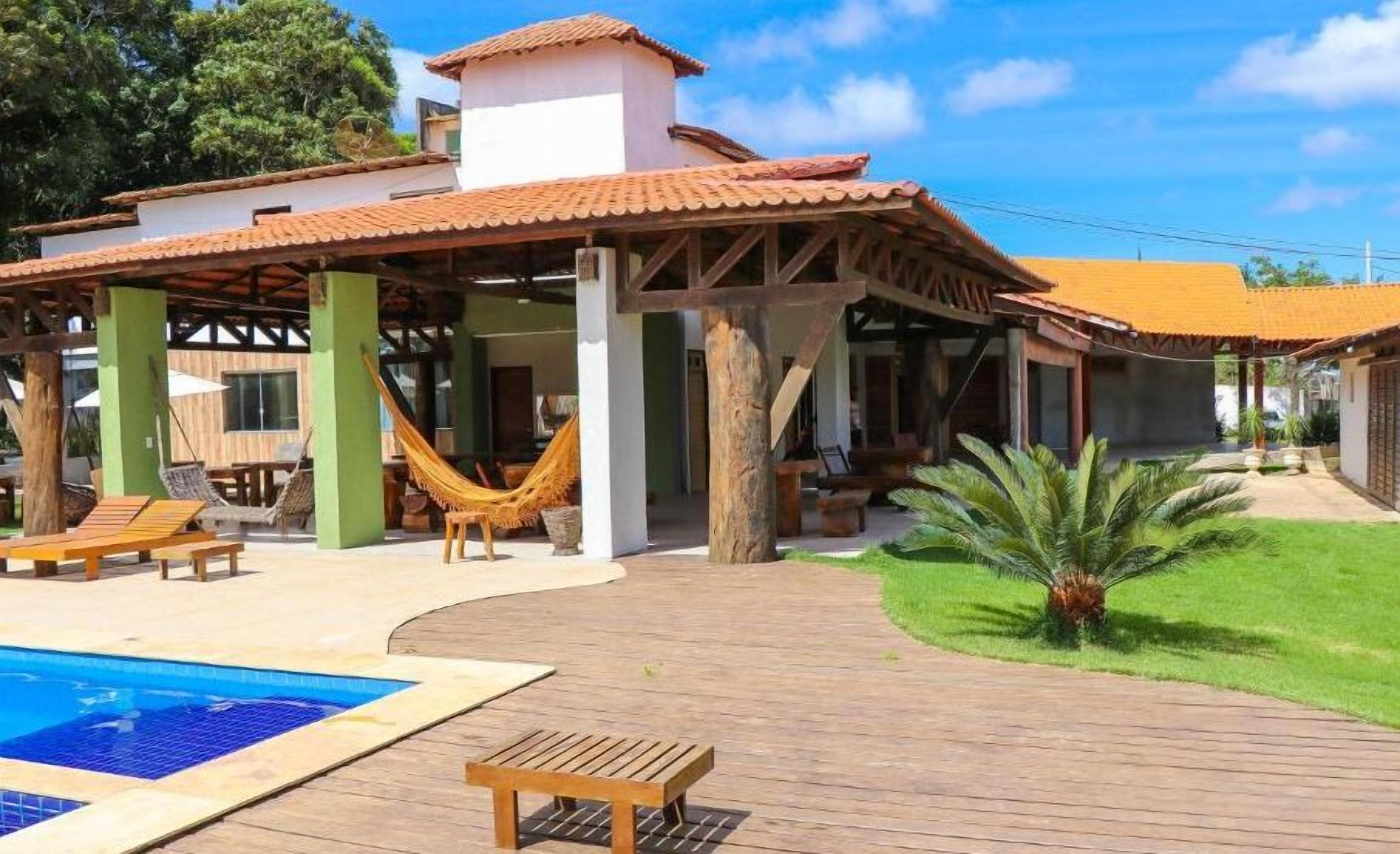 Un complexe hôtelier doté d’une piscine, d’un espace extérieur aménagé et d’un patio couvert.