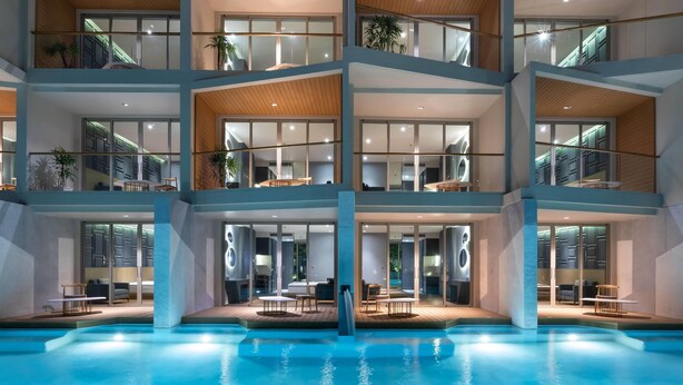 A multi-story hotel with a swimming pool, balconies, and modern interior design. - Wyndham Grand Nai Harn Beach Phuket (Rawai)
