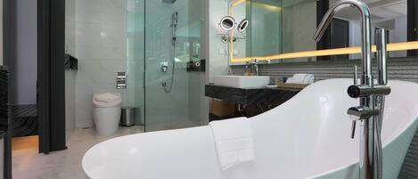 A modern bathroom with a freestanding bathtub, a glass-enclosed shower, and a vanity with a mirror.