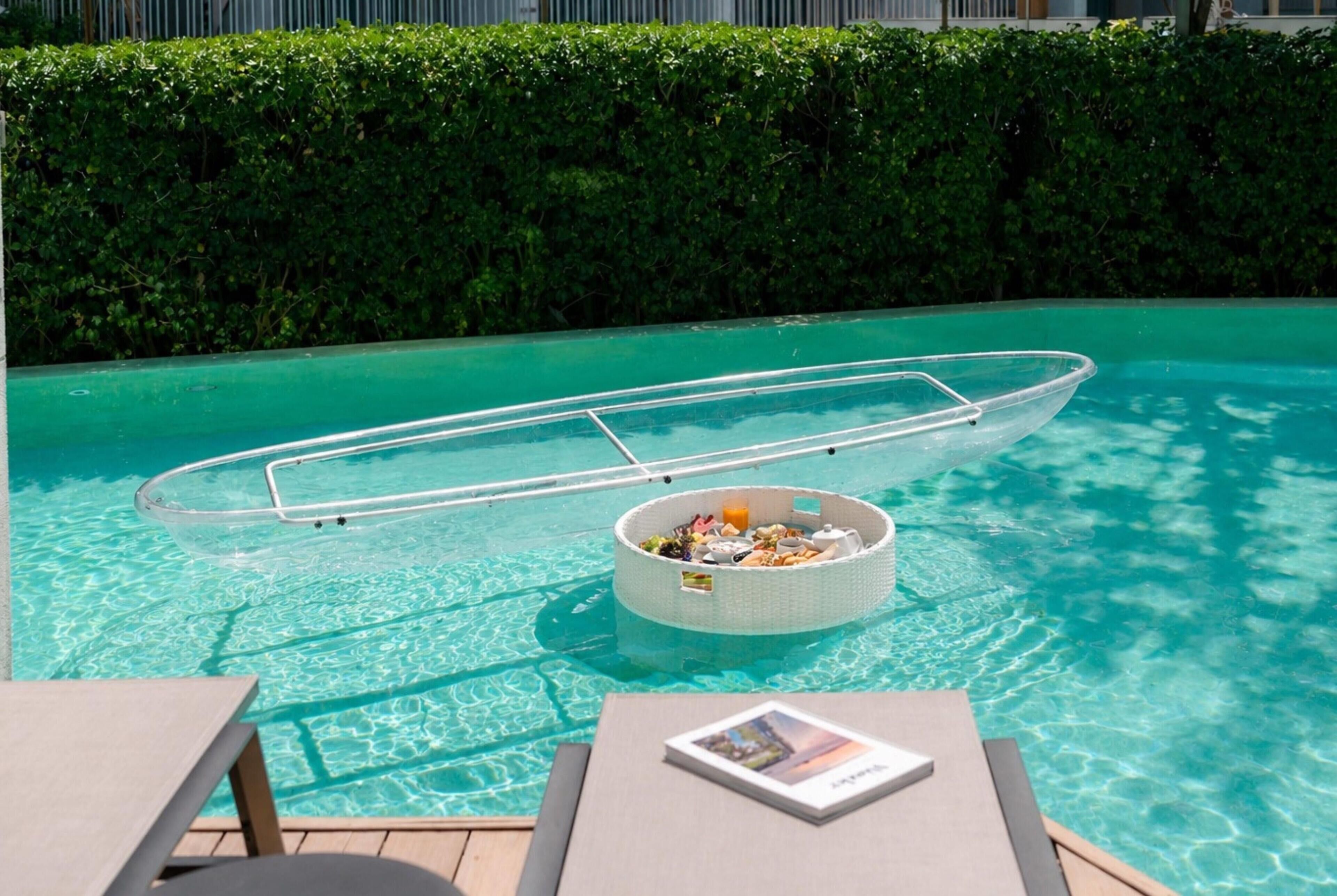 A pool with a floating boat and a basket of food.