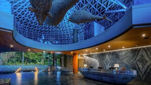 A spacious lobby with a modern design, a reception desk, and a unique ceiling structure. - Wyndham Grand Nai Harn Beach Phuket (Rawai)