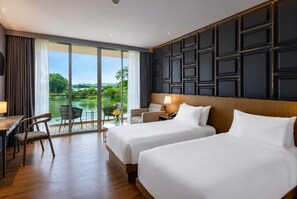 Una habitación de hotel con dos camas, un escritorio, una silla y vistas a un lago.