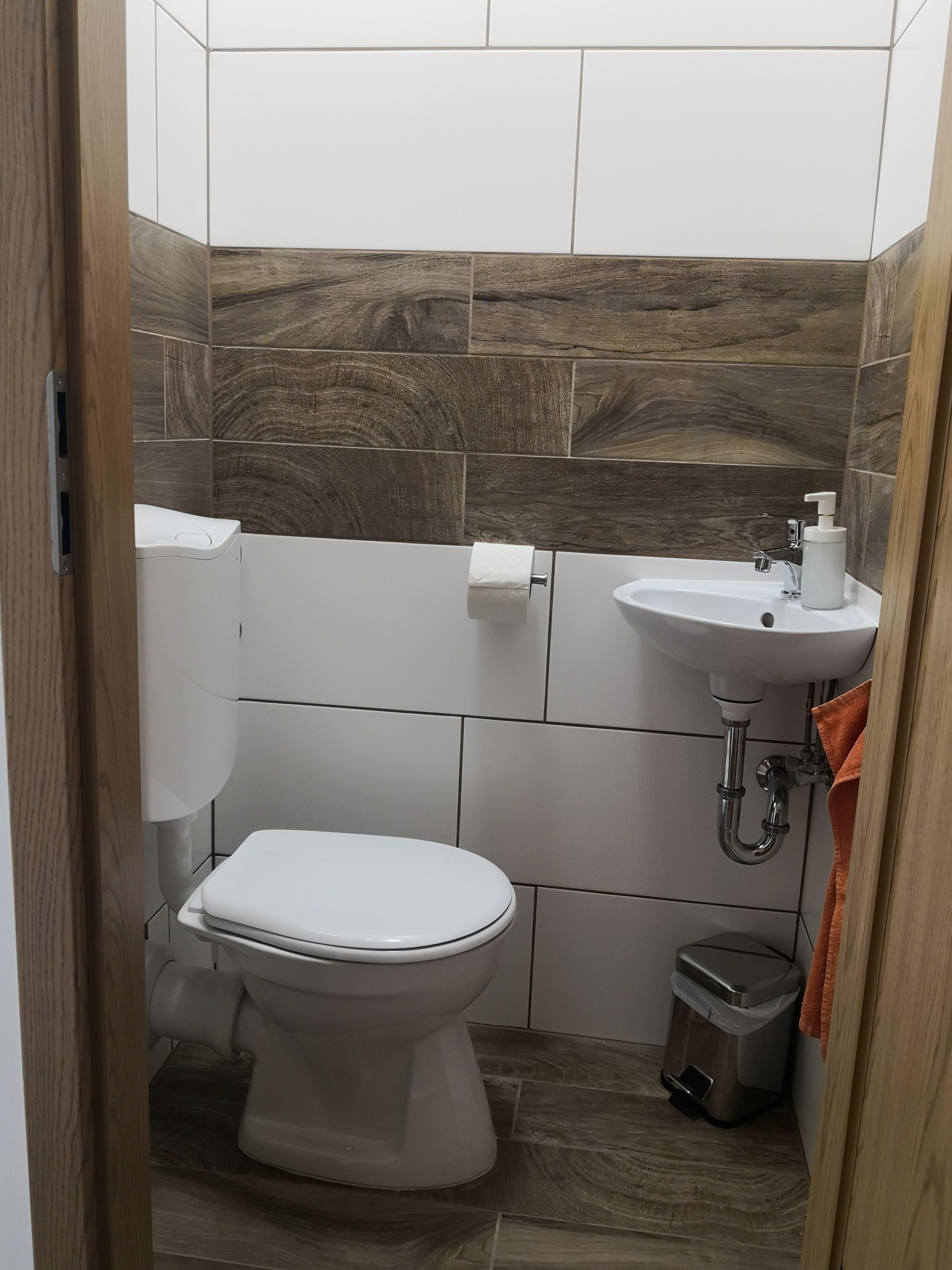 Une petite salle de bain comprenant des toilettes, un lavabo et une poubelle.