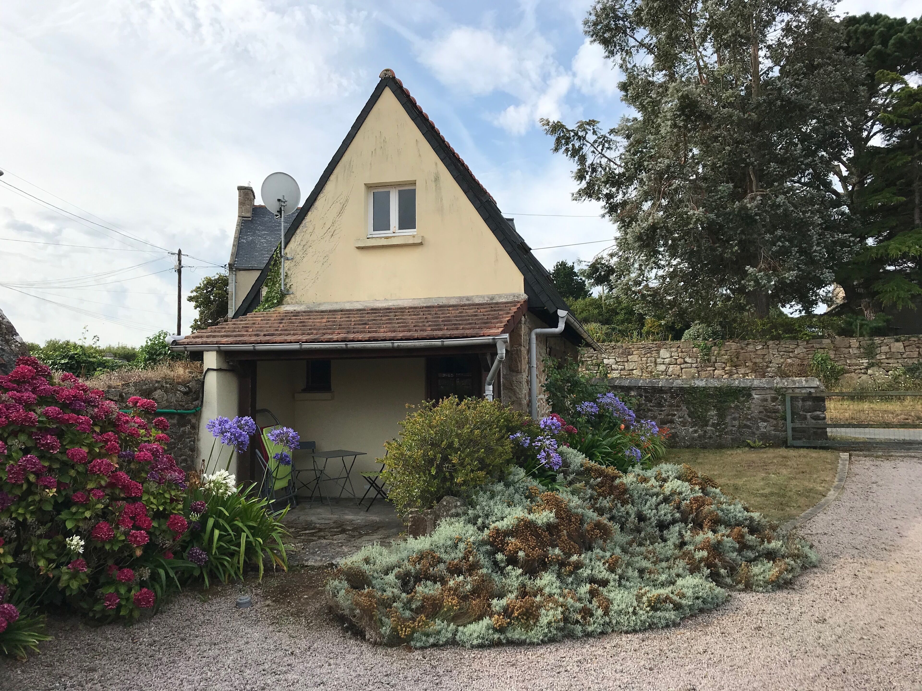 A house with a sloped roof, a small window, and a satellite dish.