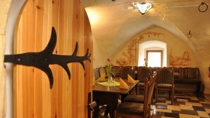 Un comedor con paredes de madera, piso a cuadros y una mesa dispuesta para dos.